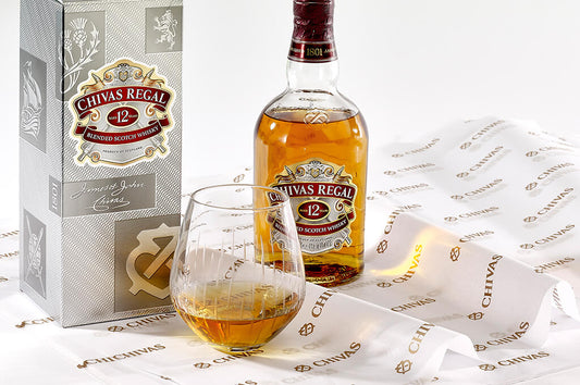 A bottle of chivas regal expertly displayed on custom printed Chivas tissue paper for gift packaging that works to elevate the unboxing experience